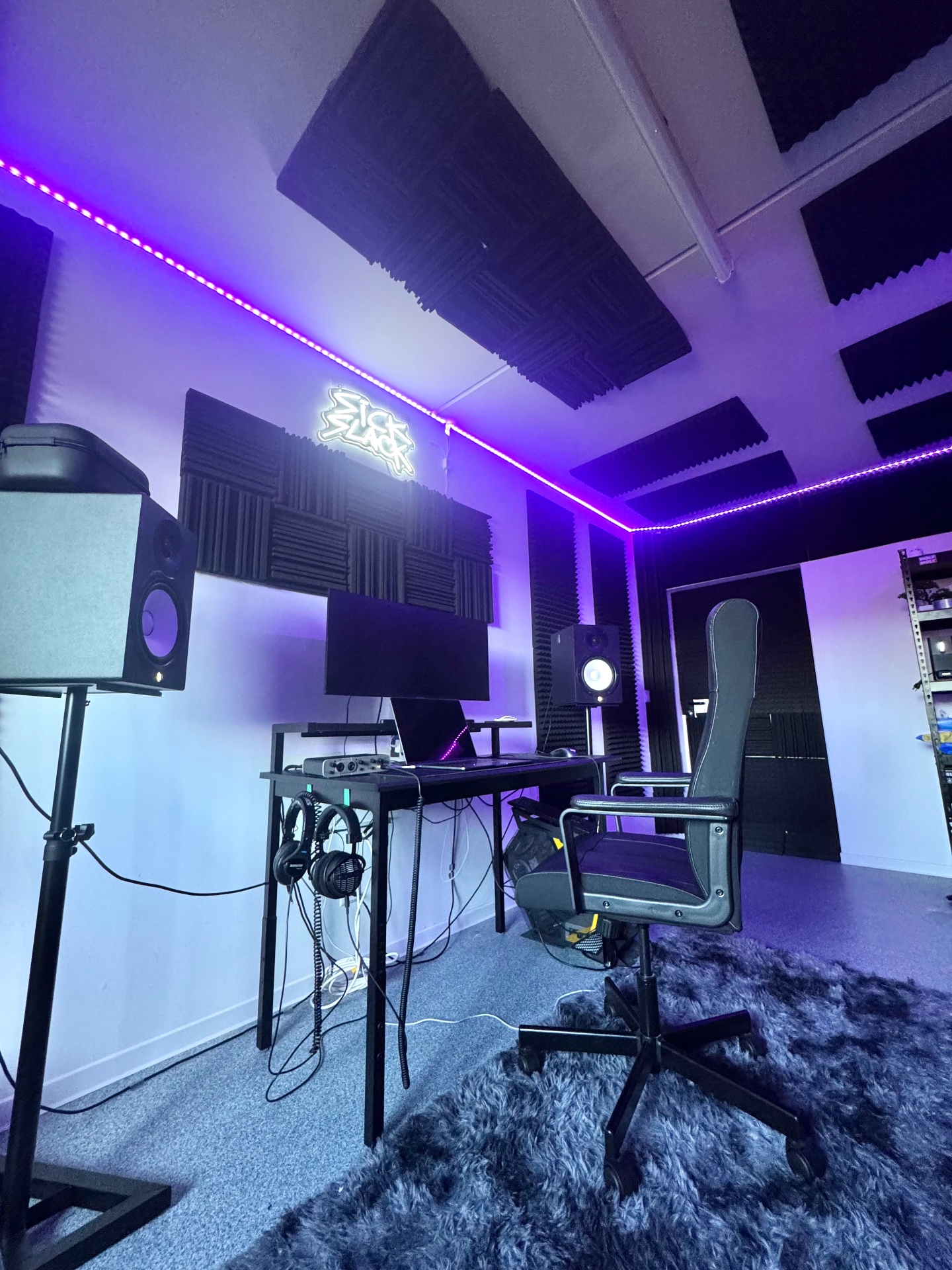 Sick Slack studio desk with monitors and neon sign